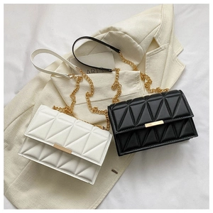Close-up of quilted pattern details and gold metal buckle on leather chain bags