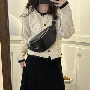 Gros plan du sac de poitrine en cuir noir avec broderie rose et fermeture éclair en argent