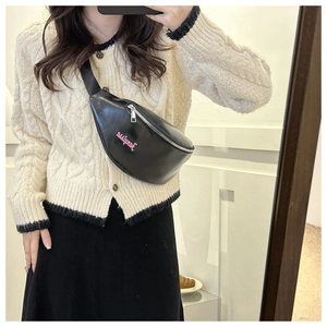 Détail du sac ceinture en similicuir noir avec broderie rose et fermeture éclair argent
