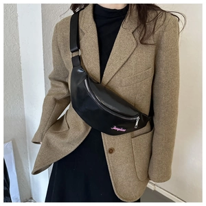 Détail du sac de poitrine en cuir noir avec broderie rose et fermeture éclair en métal