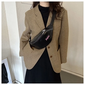 Détail du sac de poitrine en cuir noir avec broderie Fanyissa rose et fermeture éclair argent
