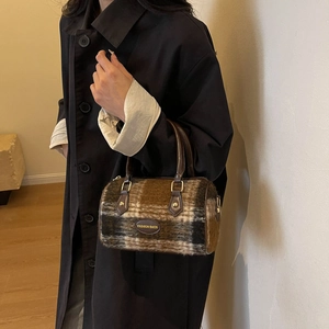 Retro plaid woolen barrel bag with leather handles and fashion logo in a lifestyle setting