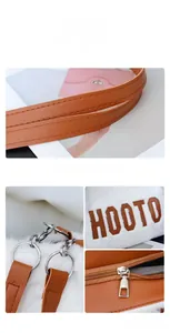 Detail showing white plush tote bag with brown HOOTO letters and leather straps