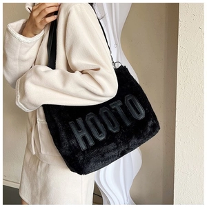 Detail of the soft black plush tote bag featuring HOOTO embroidered lettering and leather strap