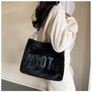 Detail of black faux fur tote bag with HOOTO leather patch and metal ring strap