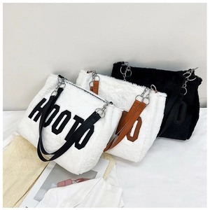 Detail of plush HOOTO tote bags in black and white with metal chains and leather straps