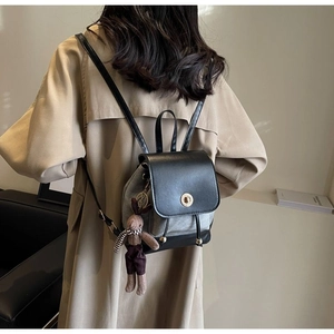 Detail of mini canvas backpack with black leather flap and cute rabbit charm
