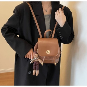Detail of vintage brown leather backpack with gold ring clasp and cute rabbit charm