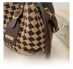 Close-up of houndstooth fabric texture and leather trim on vintage bucket bag