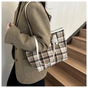 Dettaglio borsa tote in tweed a quadri con eleganti spalline in pelle bianca raffinata