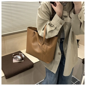 Gros plan d'un sac cabas marron en cuir minimaliste porté pour un look urbain chic