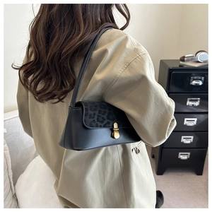 Chic leopard print flap handbag with gold twist lock shown on a beige trench coat