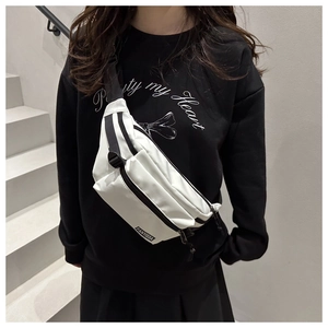 Detailansicht einer weißen Crossbody-Brusttasche aus Nylon mit schwarzem Gurt am Model