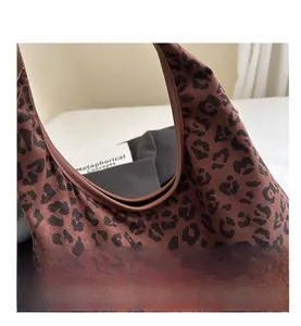 Detailed close-up of leopard print tote bag with matte texture and leather piping