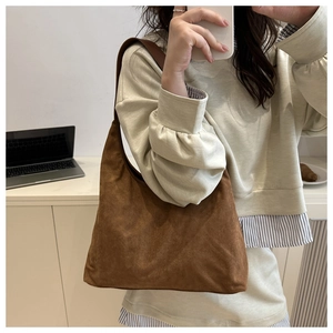 Close-up of brown suede hobo bag with a soft texture and wide shoulder strap
