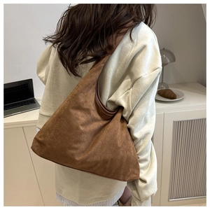 Brown faux suede tote bag shown on model in a minimalist modern office setting