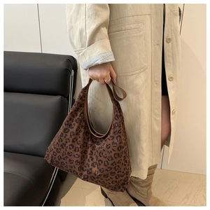 Detail of large leopard print hobo bag worn with a beige trench coat for a chic look