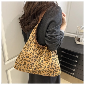 Retro leopard print suede tote bag with brown leather trim shown on model shoulder