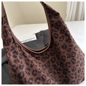 Close-up of brown leopard print underarm bag with faux suede texture and leather piping