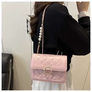 Detail of light pink quilted chain bag with elegant pearl strap and gold ring lock