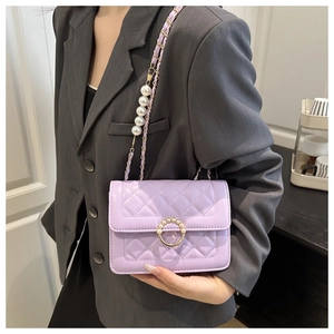 Detailed view of lavender quilted crossbody bag with pearl buckle and chain strap