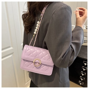 Detail of lavender quilted shoulder bag with pearl accents and gold metal closure