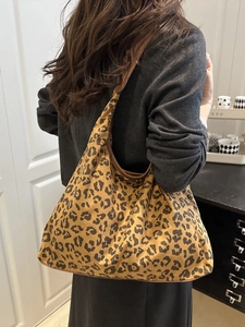 Leopard print underarm shoulder bag with brown leather trim shown in a lifestyle setting