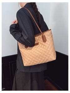 Quilted tote bag in khaki with brown straps, shown from a side-rear perspective on model