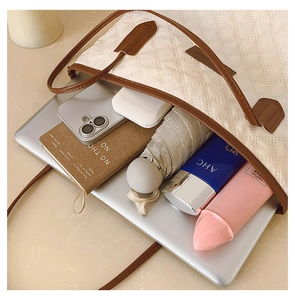 Spacious interior of beige quilted tote bag showing a laptop and daily essentials