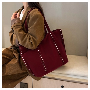 Détail du sac cabas en velours bordeaux avec clous argentés et rayures verticales