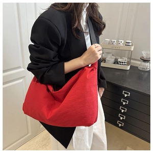 Gros plan du sac hobo en nylon rouge avec large bandoulière et design spacieux