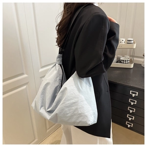Detailed shot of a light blue nylon dumpling bag worn over the shoulder for daily commute