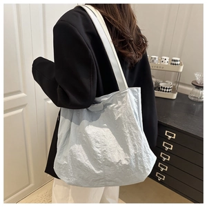 Close-up of light blue wrinkled fabric texture and fashion label on large tote bag