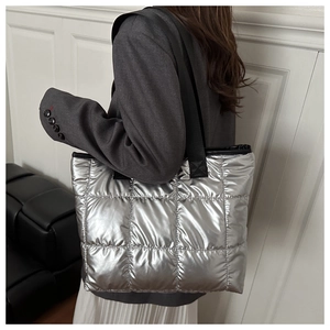 Silver quilted tote bag with metallic finish worn with a grey blazer and white skirt