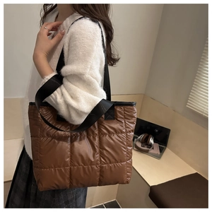 Detail der gesteppten Nylon-Schultertasche in Dunkelbraun mit gepolsterter Textur und Gurt