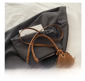 Detail of leopard print suede bucket bag with adjustable brown strap and gold hardware