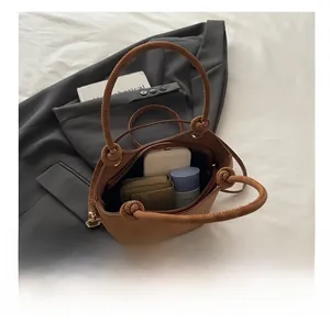 Detail view of large brown suede bucket bag showing spacious interior and daily essentials
