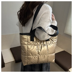 Detail of metallic gold quilted tote bag showing large capacity and puffy nylon texture