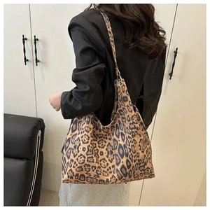 Detailed view of the leopard print hobo shoulder bag with wide strap on a model