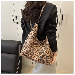 Détail du sac hobo en toile léopard montrant la texture et la large bandoulière