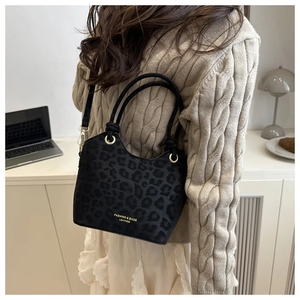 Close-up of leopard print handbag with woven rope handle and gold metal hardware