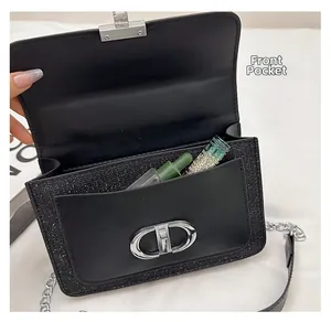 Close-up of the front pocket and metal CD buckle on a black sequin crossbody bag