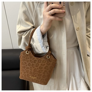 Detail of leopard print bucket bag showing suede texture and metal ring handle