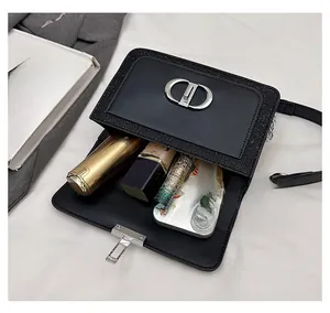 Detail view of black sequined flap bag showing capacity with makeup and phone storage