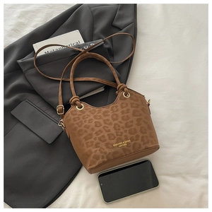 Close-up of leopard print handbag with golden text detail and adjustable strap