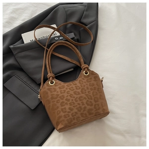 Macro detail of brown leopard print texture and golden eyelet on stylish handbag