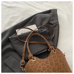 Close-up of leopard print handbag with knotted handle and gold hardware detail