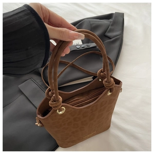 Detail of a brown leopard print suede bucket bag with FASHION & BAGS gold lettering