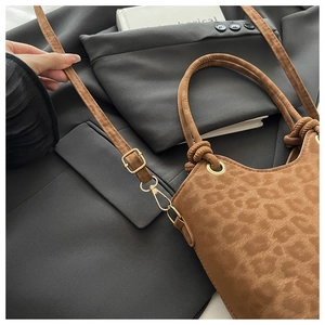 Close-up of leopard print handbag with plush texture and gold buckle detail