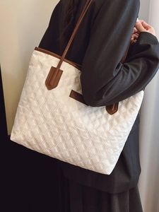 Quilted beige tote bag with brown straps and spacious interior for casual daily use